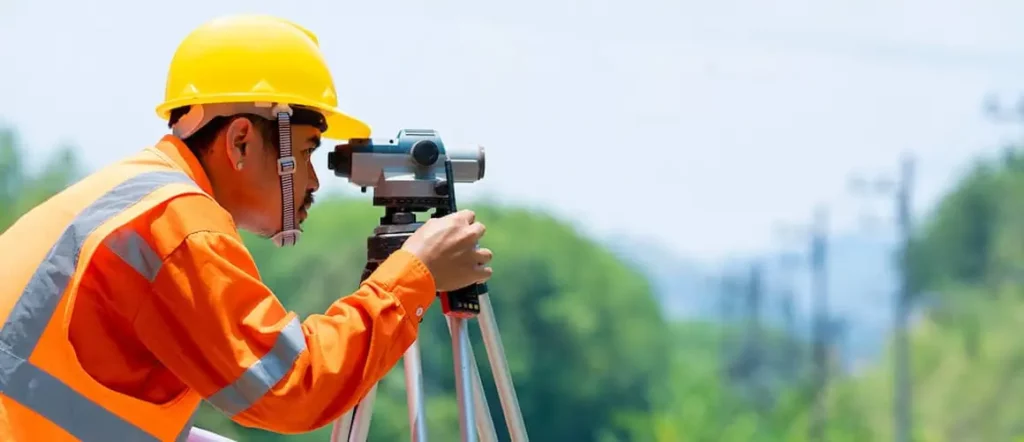 Land surveyor working in corners of the field at a service business location in Exton pa
