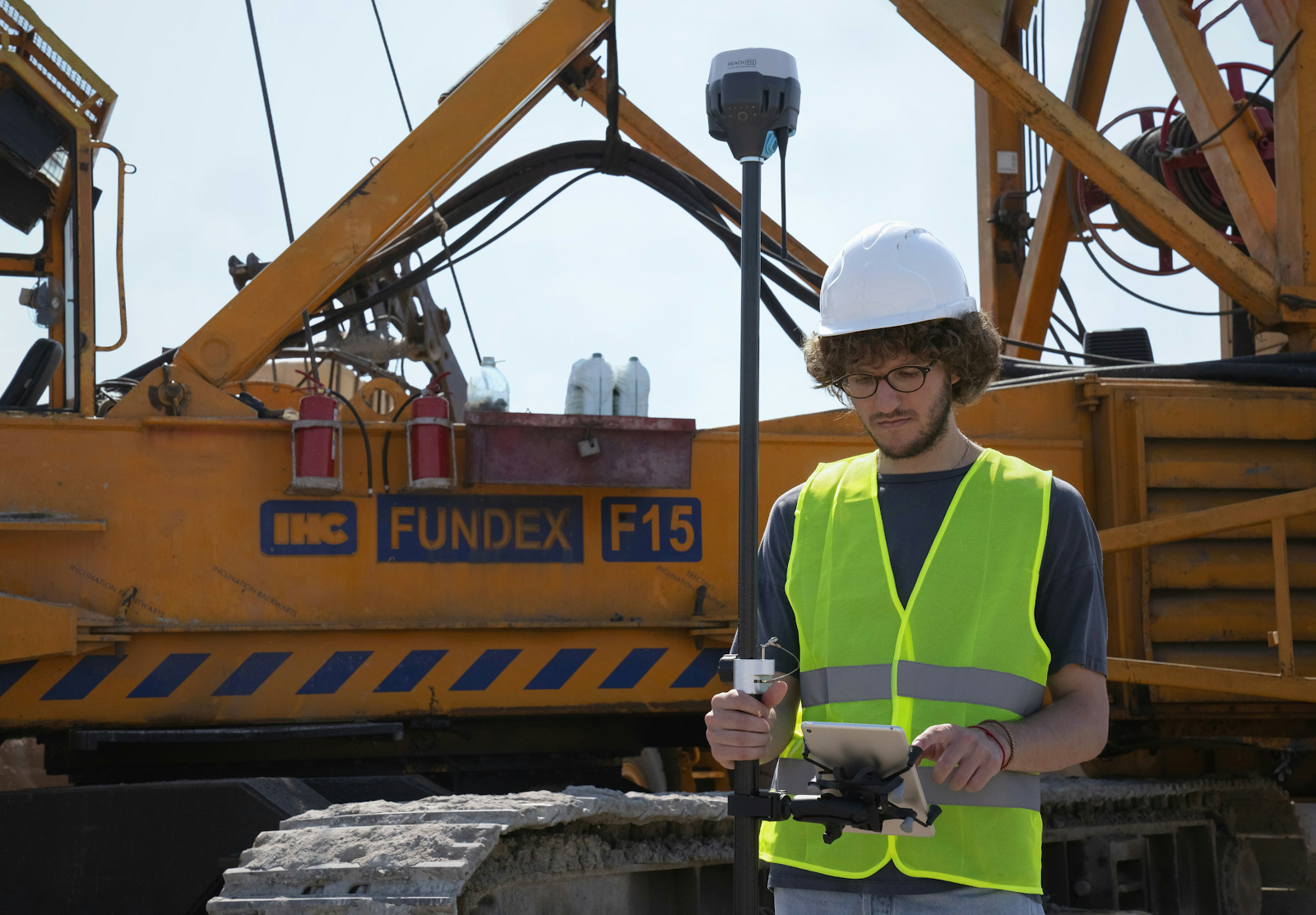 A land surveyor using surveying equipment on a construction site